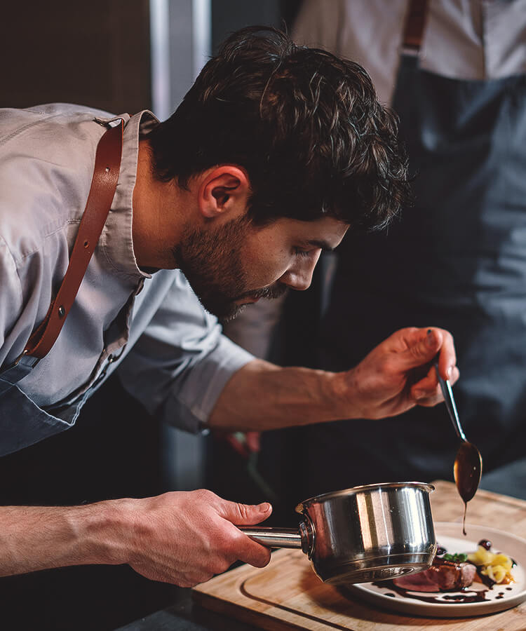 Chef meticulously plating a gourmet course